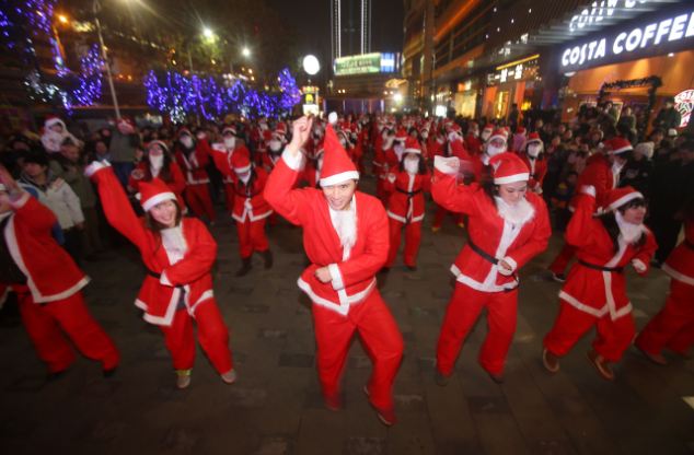 WUHAN, CHINA - DECEMBER 24: People dressed as Santa Claus dance 'Gangnam Style' on Christmas Eve on December 24, 2012 in Wuhan, Hubei Province of China. PHOTOGRAPH BY China Foto Press / Barcroft Media UK Office, London. T +44 845 370 2233 W www.barcroftmedia.com USA Office, New York City. T +1 212 796 2458 W www.barcroftusa.com Indian Office, Delhi. T +91 11 4053 2429 W www.barcroftindia.com